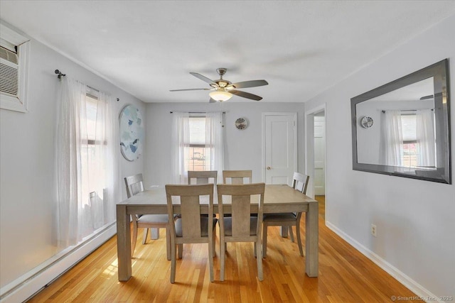 dining area with plenty of natural light, a baseboard radiator, light wood finished floors, and a ceiling fan