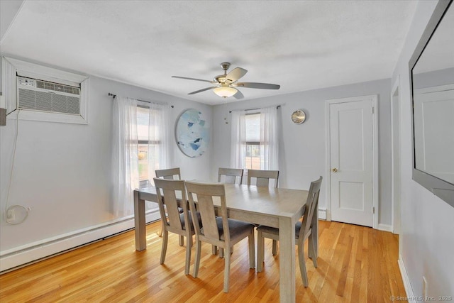 dining area with a wall unit AC, a ceiling fan, baseboards, a baseboard radiator, and light wood-style floors