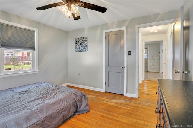 bedroom featuring baseboards, ceiling fan, and light wood finished floors