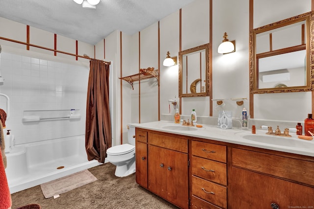 bathroom with a sink, a stall shower, toilet, and double vanity
