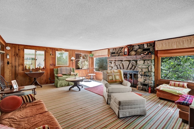 living room featuring wooden walls, carpet floors, plenty of natural light, and a textured ceiling