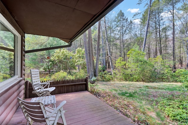 wooden terrace featuring a view of trees