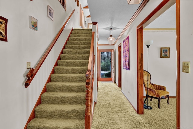staircase with baseboards, carpet flooring, and ornamental molding
