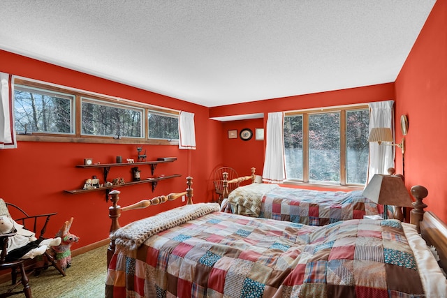 bedroom with baseboards, a textured ceiling, and carpet