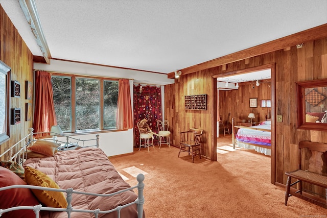 bedroom with carpet floors, wood walls, and a textured ceiling