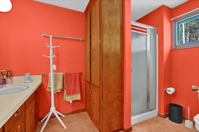 full bathroom with baseboards, a shower stall, and vanity
