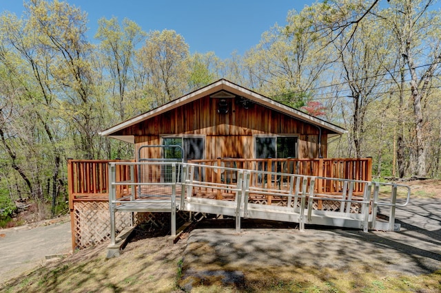 view of front of property featuring a deck and a wooded view