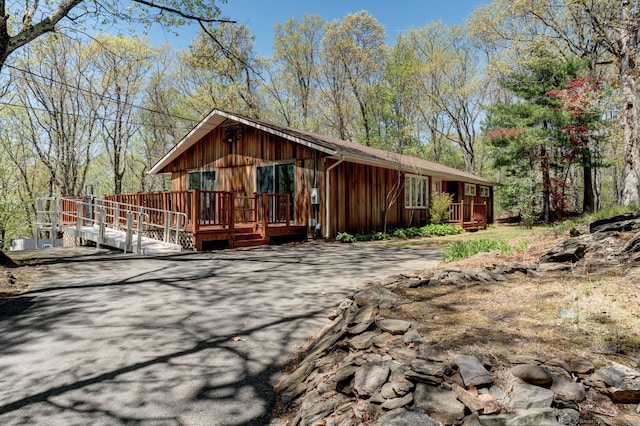 rear view of house featuring a wooden deck and board and batten siding
