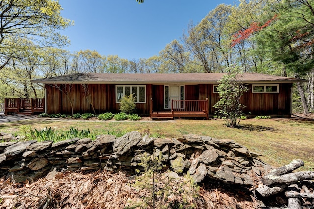 ranch-style home featuring a front yard and a deck