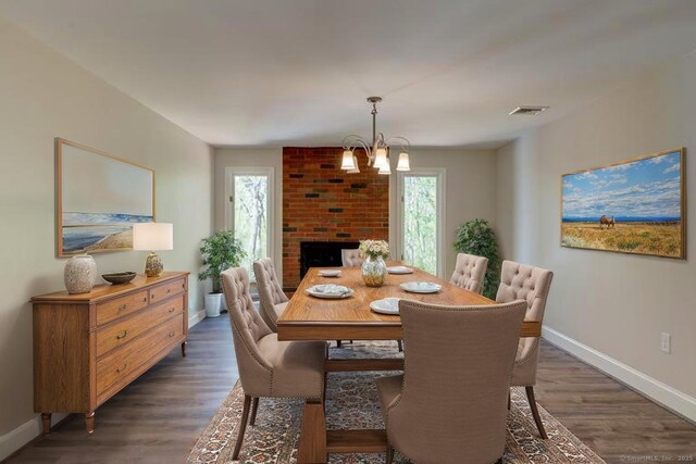 dining area featuring dark wood-style flooring, baseboards, a chandelier, and visible vents