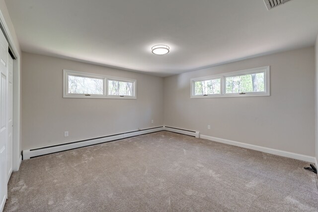 unfurnished bedroom with carpet flooring, baseboard heating, baseboards, visible vents, and a closet