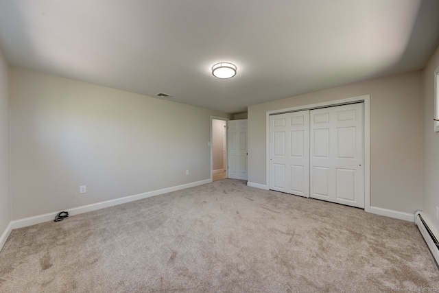 unfurnished bedroom with baseboards, a baseboard radiator, carpet flooring, and visible vents