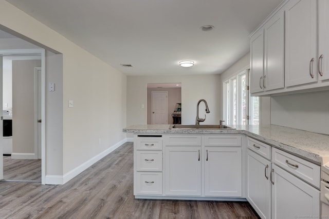 1037 Bartholomew Rd, Middletown, CT 06457 - kitchen with a sink, a peninsula, white cabinets, light countertops, and baseboards