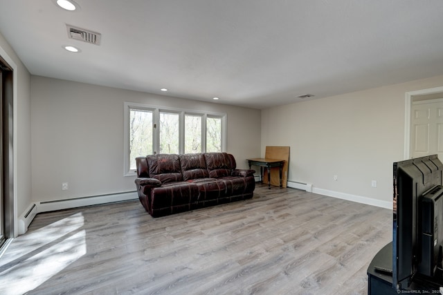 living area with a baseboard heating unit, recessed lighting, and visible vents