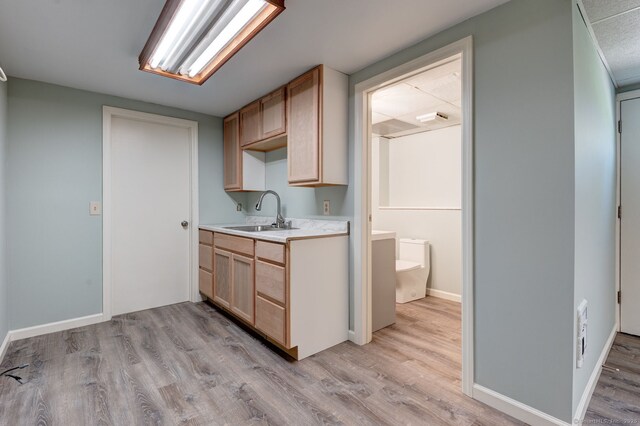 1037 Bartholomew Rd, Middletown, CT 06457 - kitchen with a sink, light countertops, light wood finished floors, light brown cabinets, and baseboards