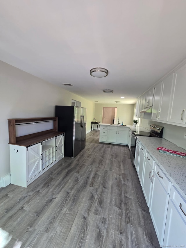 1037 Bartholomew Rd, Middletown, CT 06457 - kitchen with stainless steel appliances, a peninsula, dark wood-style floors, white cabinetry, and under cabinet range hood