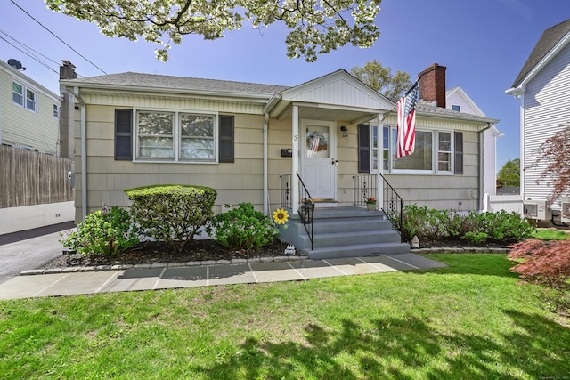 bungalow with fence, a chimney, and a front yard