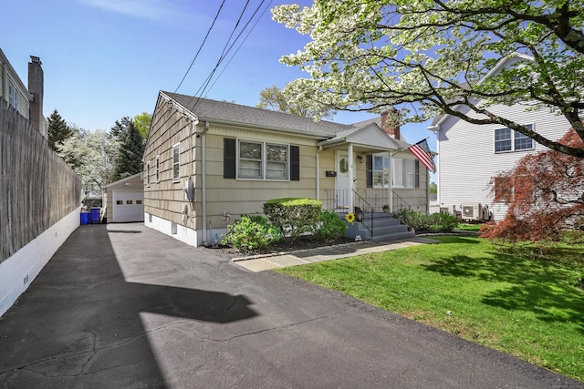 view of front of property with a chimney, a front lawn, roof with shingles, and a garage