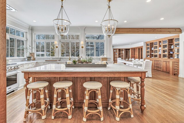 kitchen with white cabinets, light countertops, a chandelier, high end stove, and recessed lighting