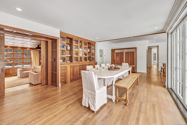 dining room with ornamental molding and light wood-style floors