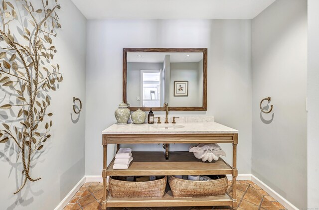 bathroom with baseboards, vanity, and recessed lighting