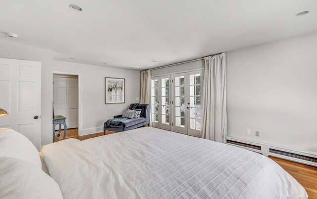 bedroom featuring recessed lighting, baseboards, a baseboard heating unit, and wood finished floors