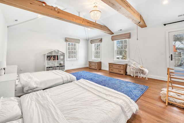 bedroom featuring multiple windows, lofted ceiling with beams, and wood finished floors