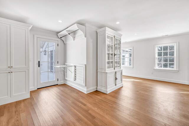 interior space with baseboards, ornamental molding, recessed lighting, and light wood-style flooring