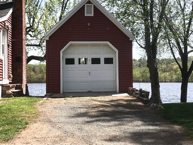 detached garage featuring a water view and driveway