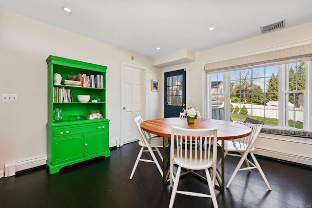 dining space with plenty of natural light, baseboard heating, dark wood finished floors, and visible vents