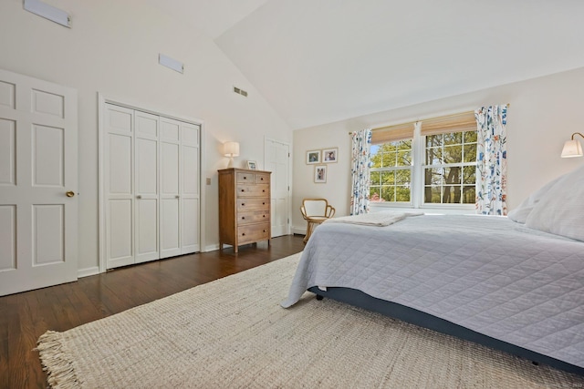 bedroom with visible vents, wood finished floors, and high vaulted ceiling