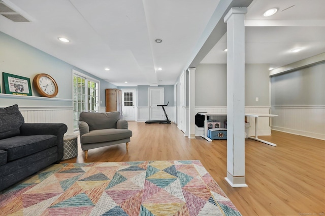 living room featuring recessed lighting, visible vents, wood finished floors, and a wainscoted wall