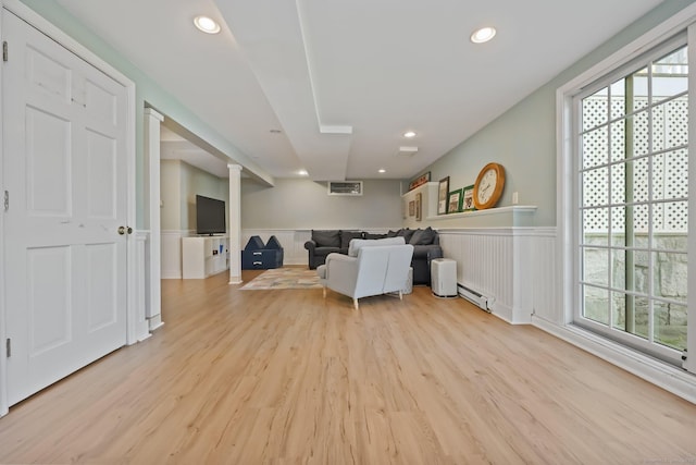 living room with light wood-style floors, recessed lighting, a baseboard heating unit, and a wainscoted wall