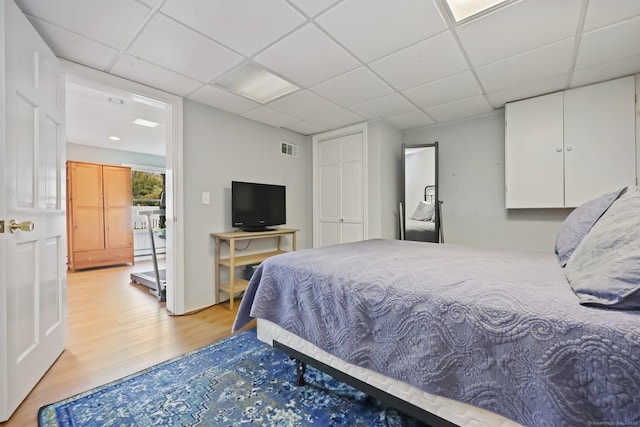 bedroom featuring visible vents, a paneled ceiling, and light wood-style floors