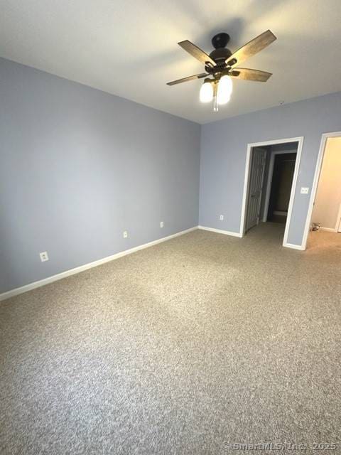 empty room with baseboards, ceiling fan, and light colored carpet