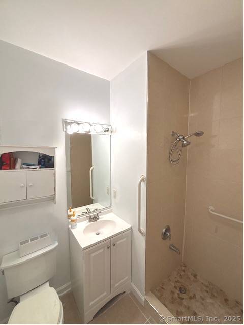full bathroom with vanity, a shower, and toilet