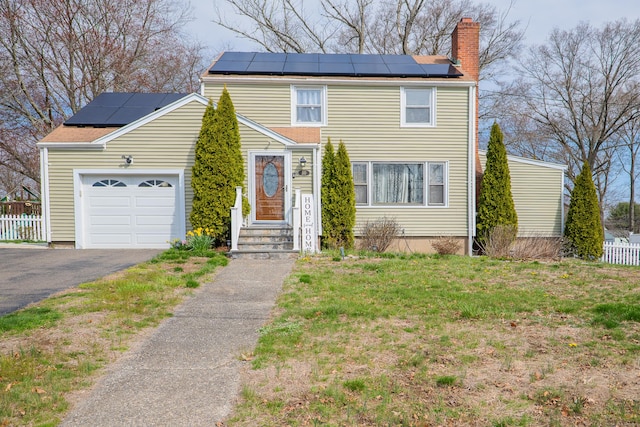 50 Fox Hill Rd, Stratford, CT 06614 - view of front of home with fence, a garage, roof mounted solar panels, a chimney, and driveway