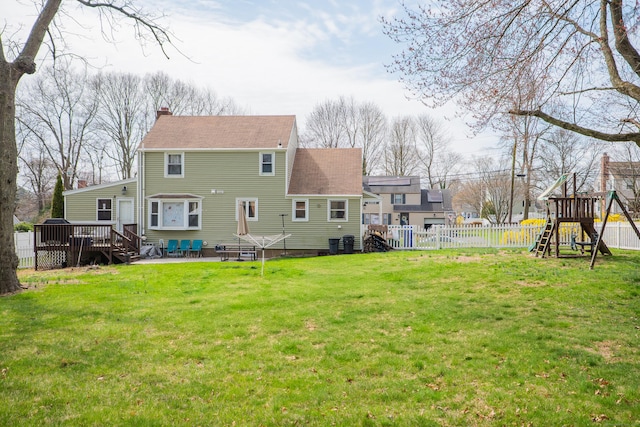 50 Fox Hill Rd, Stratford, CT 06614 - back of property with a chimney, a lawn, a wooden deck, a fenced backyard, and a playground