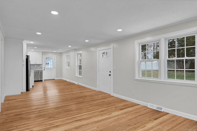 unfurnished living room with crown molding, visible vents, baseboards, light wood-type flooring, and recessed lighting