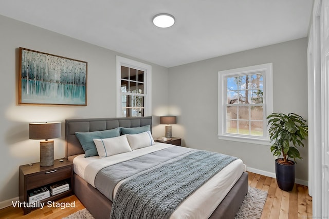bedroom with baseboards and light wood finished floors