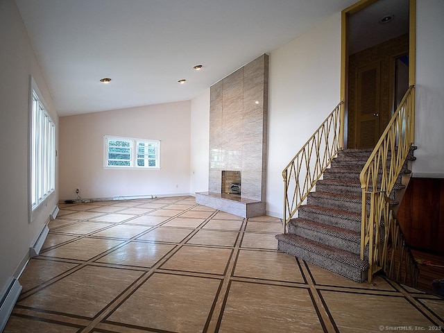 unfurnished living room with baseboards, stairway, recessed lighting, vaulted ceiling, and a premium fireplace