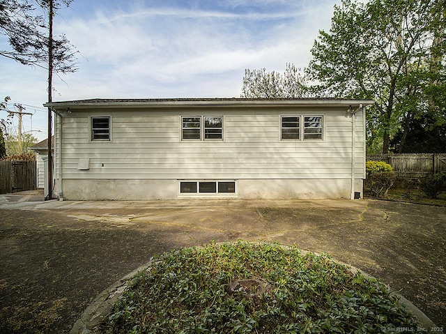 view of side of home featuring fence and a patio