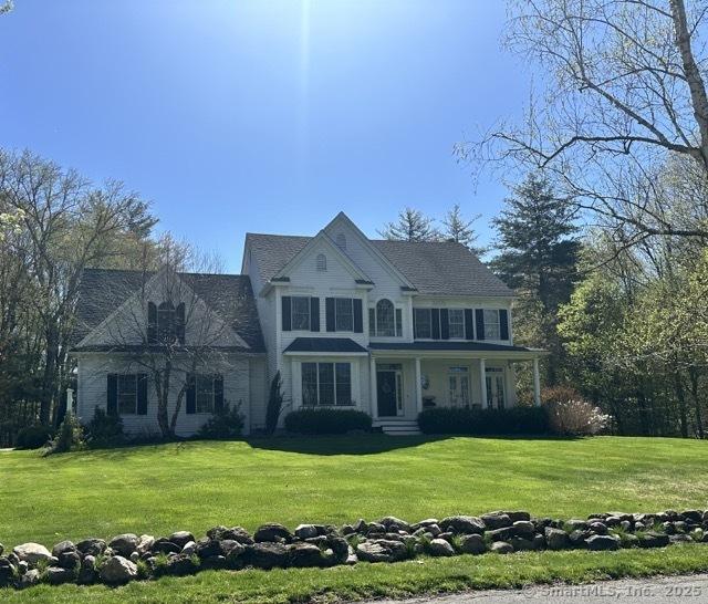 colonial inspired home featuring a front lawn