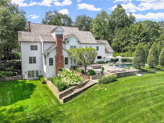 2 Grouse Path, Westport, CT 06880 - rear view of house featuring a patio area, a lawn, a chimney, and an outdoor pool