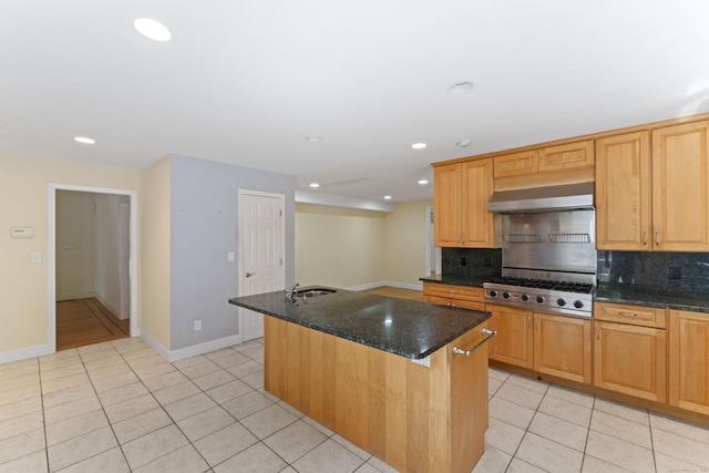 kitchen with exhaust hood, light tile patterned floors, stainless steel gas stovetop, and tasteful backsplash