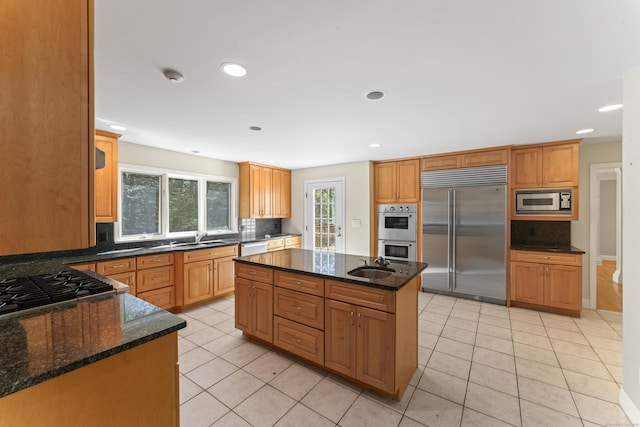 kitchen with built in appliances, decorative backsplash, and light tile patterned floors