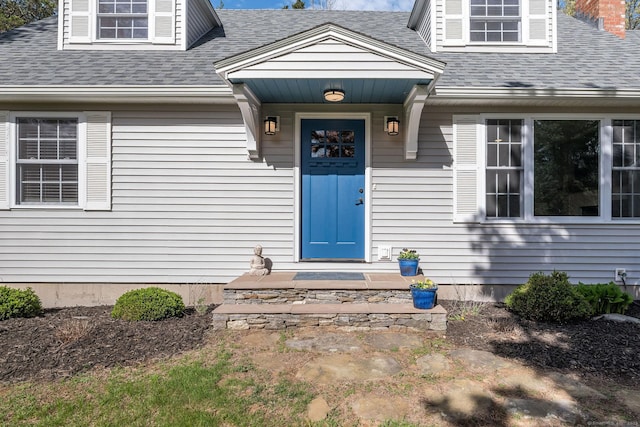 entrance to property featuring a shingled roof