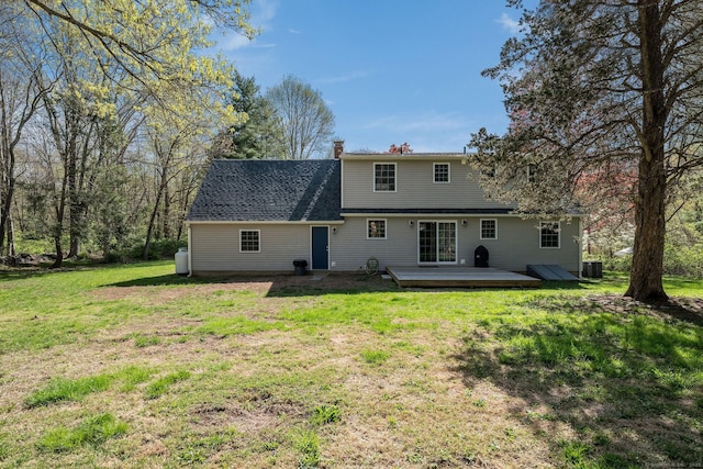 back of house with a lawn, a wooden deck, a chimney, and cooling unit