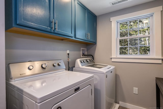 clothes washing area with cabinet space, baseboards, visible vents, and washer and clothes dryer