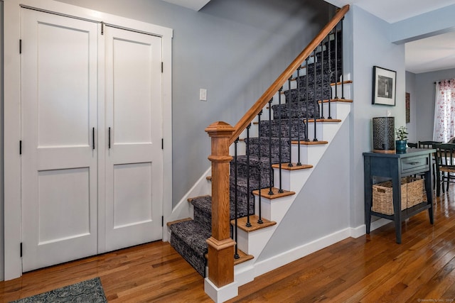 stairway with baseboards and wood finished floors